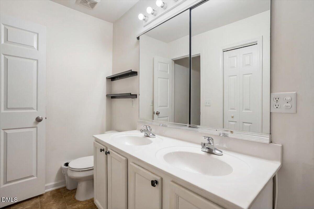 2231 Raven Road, Unit 103 Raleigh, NC 27614 - Photo 25 of 26 a bathroom with a toilet sink and mirror