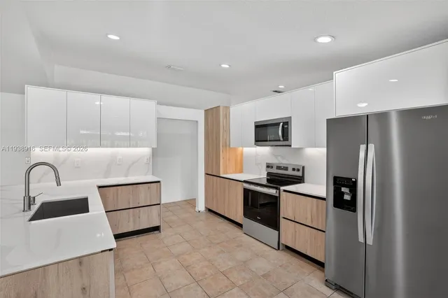a kitchen with a refrigerator and a sink