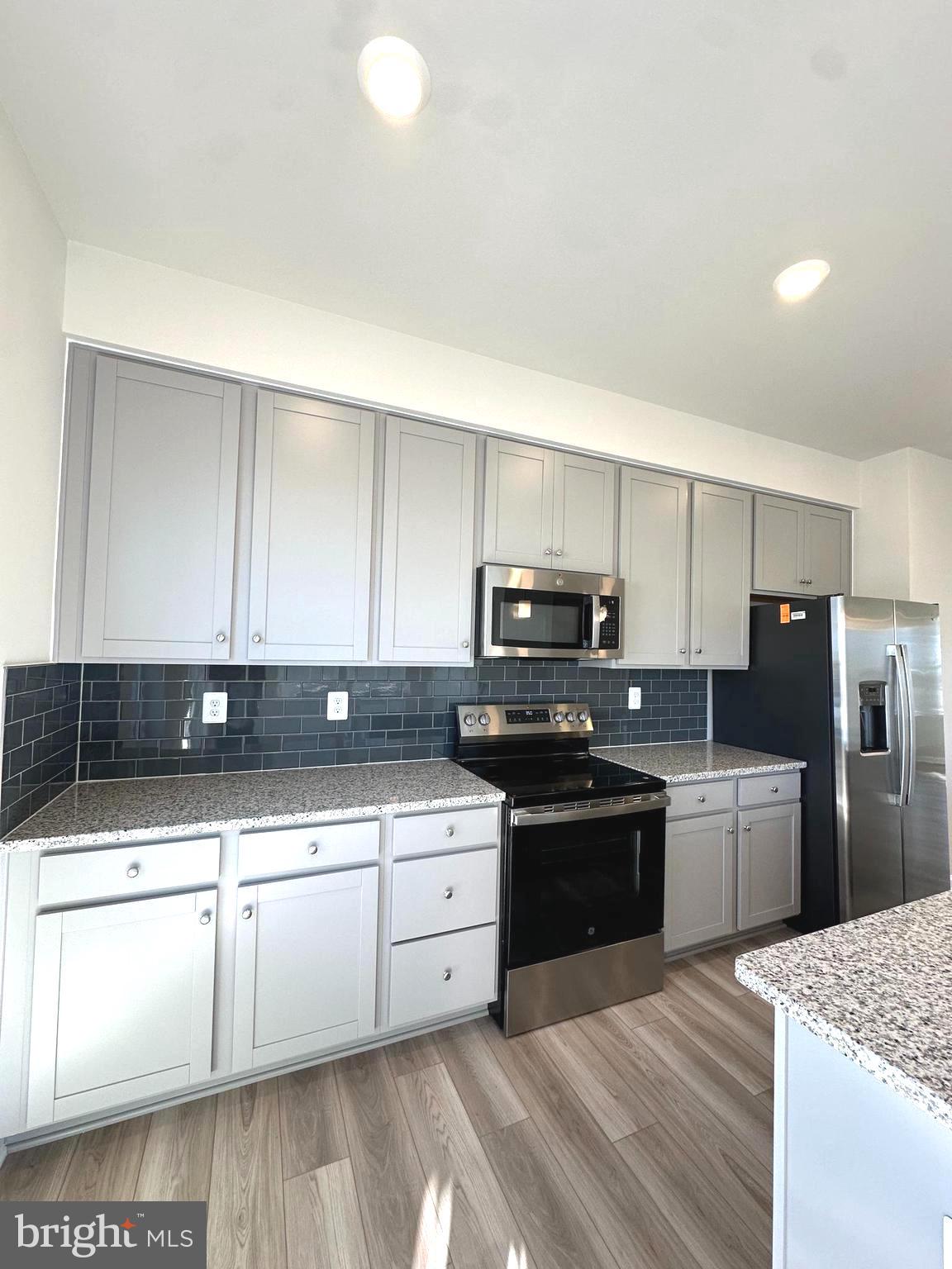 317 Short Br Drive Ranson, WV 25438 - Photo 11 of 41 a kitchen with stainless steel appliances kitchen island granite countertop a sink and white cabinets