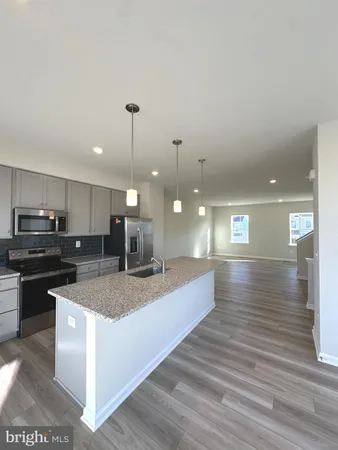 a large kitchen with kitchen island a sink stainless steel appliances and cabinets