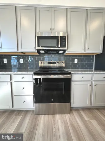 a kitchen with a stove and white cabinets