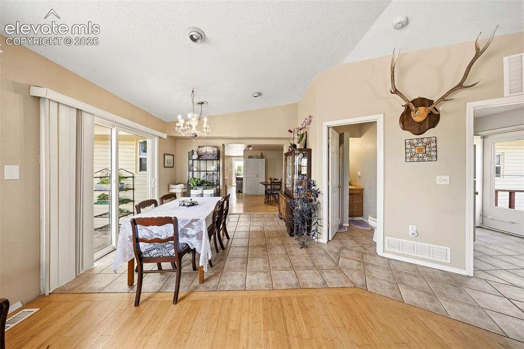 13075 Blaney Road South Peyton, CO 80831 - Photo 14 of 40 Dining area with vaulted ceilings and a chandelier lighting fixture