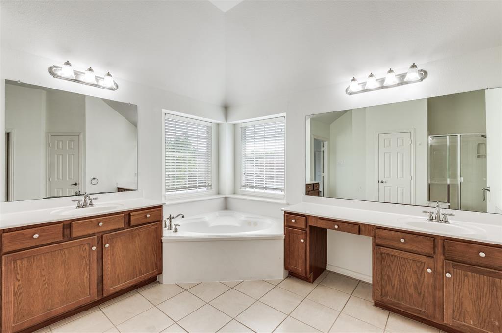 13371 Lime Ridge Drive Frisco, TX 75033 - Photo 16 of 25 Bathroom featuring a corner soaking tub, dual vanity with wood cabinetry, and tiled flooring