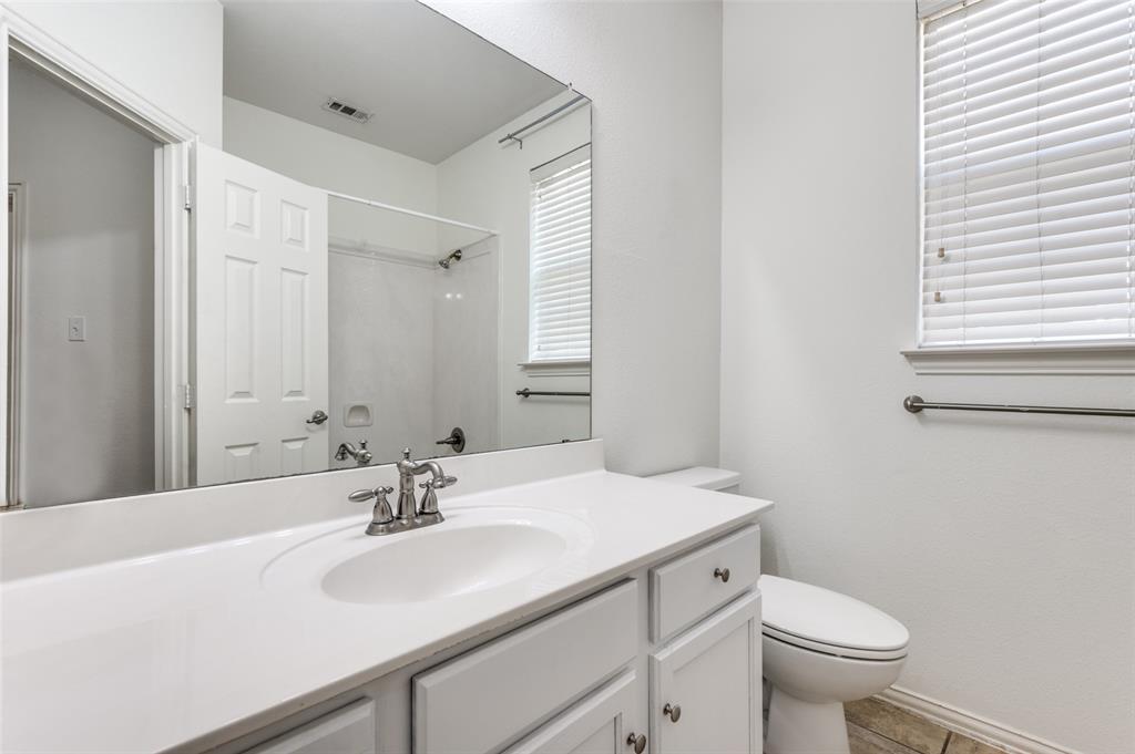 13371 Lime Ridge Drive Frisco, TX 75033 - Photo 22 of 25 Bathroom vanity with white countertop, chrome faucet, and a large mirror