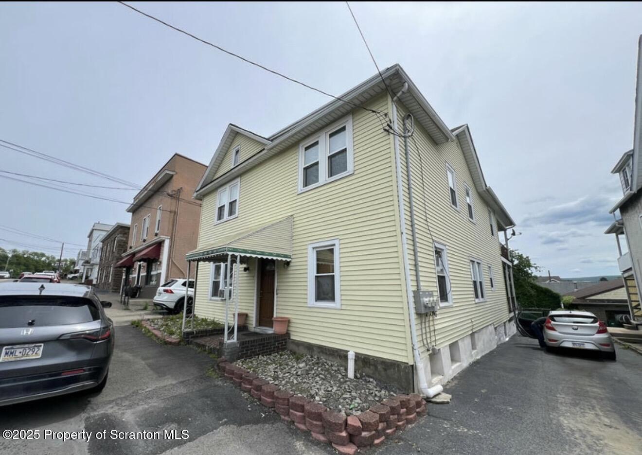 128 North Main Street, Unit 3 Old Forge, PA 18518 - Photo 1 of 8 a view of a white house and a car parked in garage