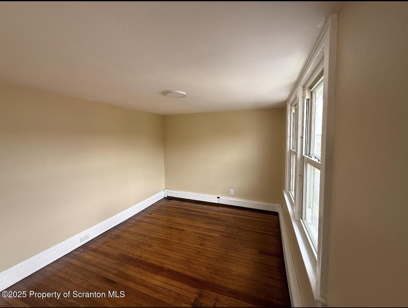 128 North Main Street, Unit 3 Old Forge, PA 18518 - Photo 2 of 8 a view of an empty room with wooden floor and a window