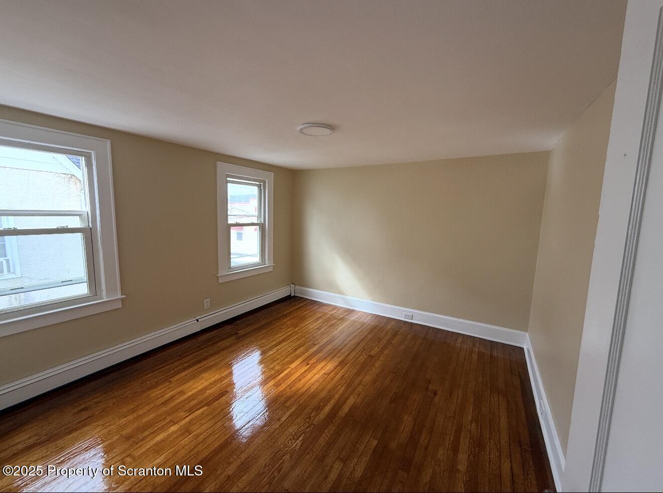 128 North Main Street, Unit 3 Old Forge, PA 18518 - Photo 3 of 8 a view of an empty room with wooden floor and a window