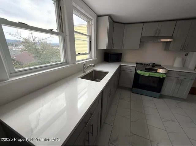 a kitchen with a stove a refrigerator and a sink