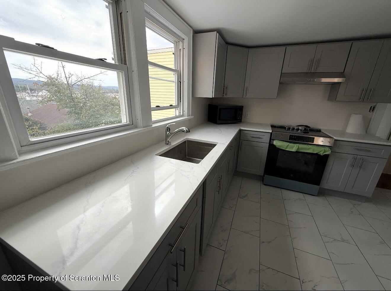 128 North Main Street, Unit 3 Old Forge, PA 18518 - Photo 5 of 8 a kitchen with a stove a refrigerator and a sink