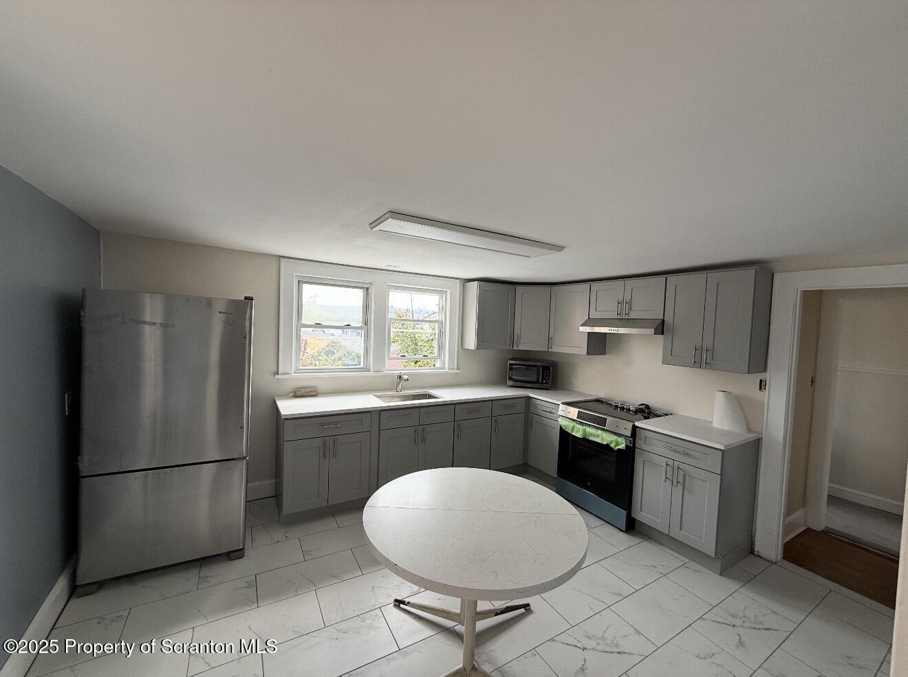 128 North Main Street, Unit 3 Old Forge, PA 18518 - Photo 6 of 8 a kitchen with stainless steel appliances a refrigerator sink and stove