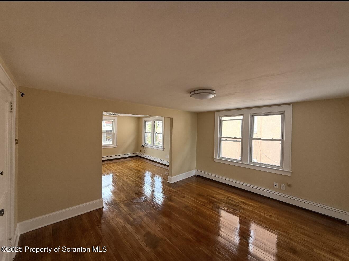 128 North Main Street, Unit 3 Old Forge, PA 18518 - Photo 7 of 8 a view of an empty room with wooden floor and window