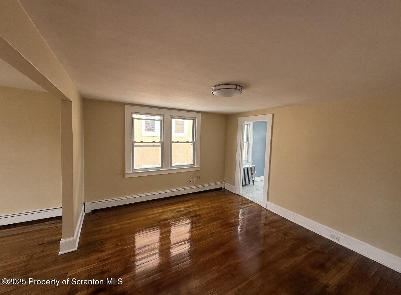 128 North Main Street, Unit 3 Old Forge, PA 18518 - Photo 8 of 8 a view of an empty room with wooden floor and a window