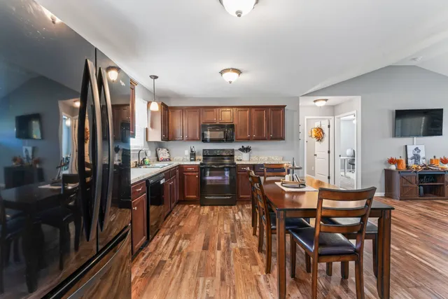 a kitchen with a dining table chairs and refrigerator