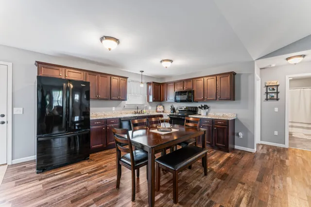 a kitchen with stainless steel appliances granite countertop a refrigerator and a stove top oven