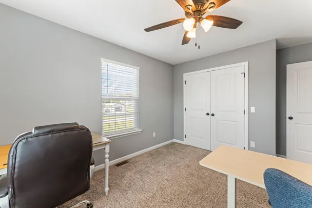 a bedroom with a bed and a chandelier fan