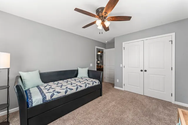 a bedroom with a bed and a ceiling fan