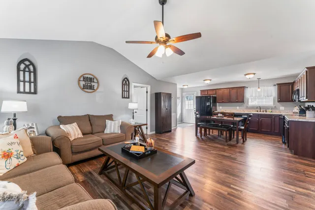 a living room with furniture kitchen view and a window