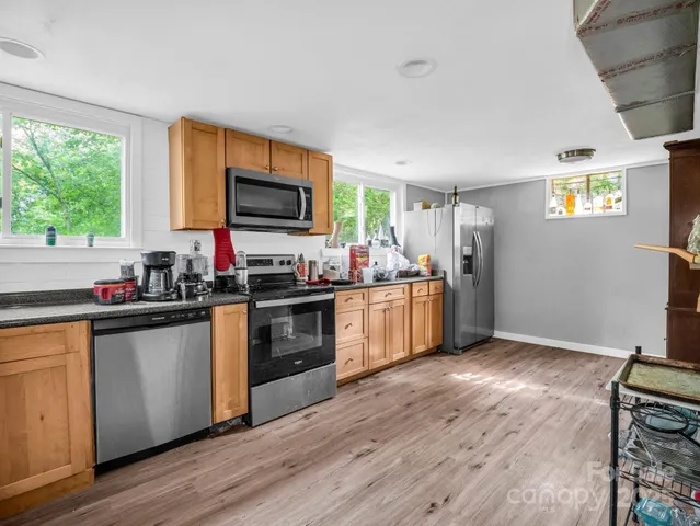 a view of a kitchen with fridge and wooden floor