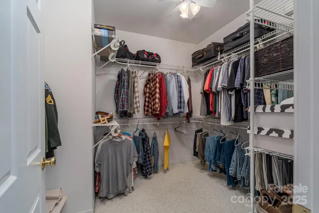 a view of walk in closet with clothes and shoes