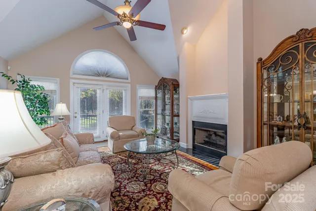 a living room with furniture a fireplace and a floor to ceiling window