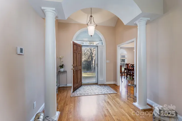a view of a hallway with wooden floor and a livingroom