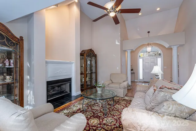 a living room with furniture a fireplace and a chandelier