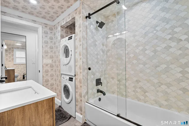 a bathroom with a granite countertop sink a toilet and shower