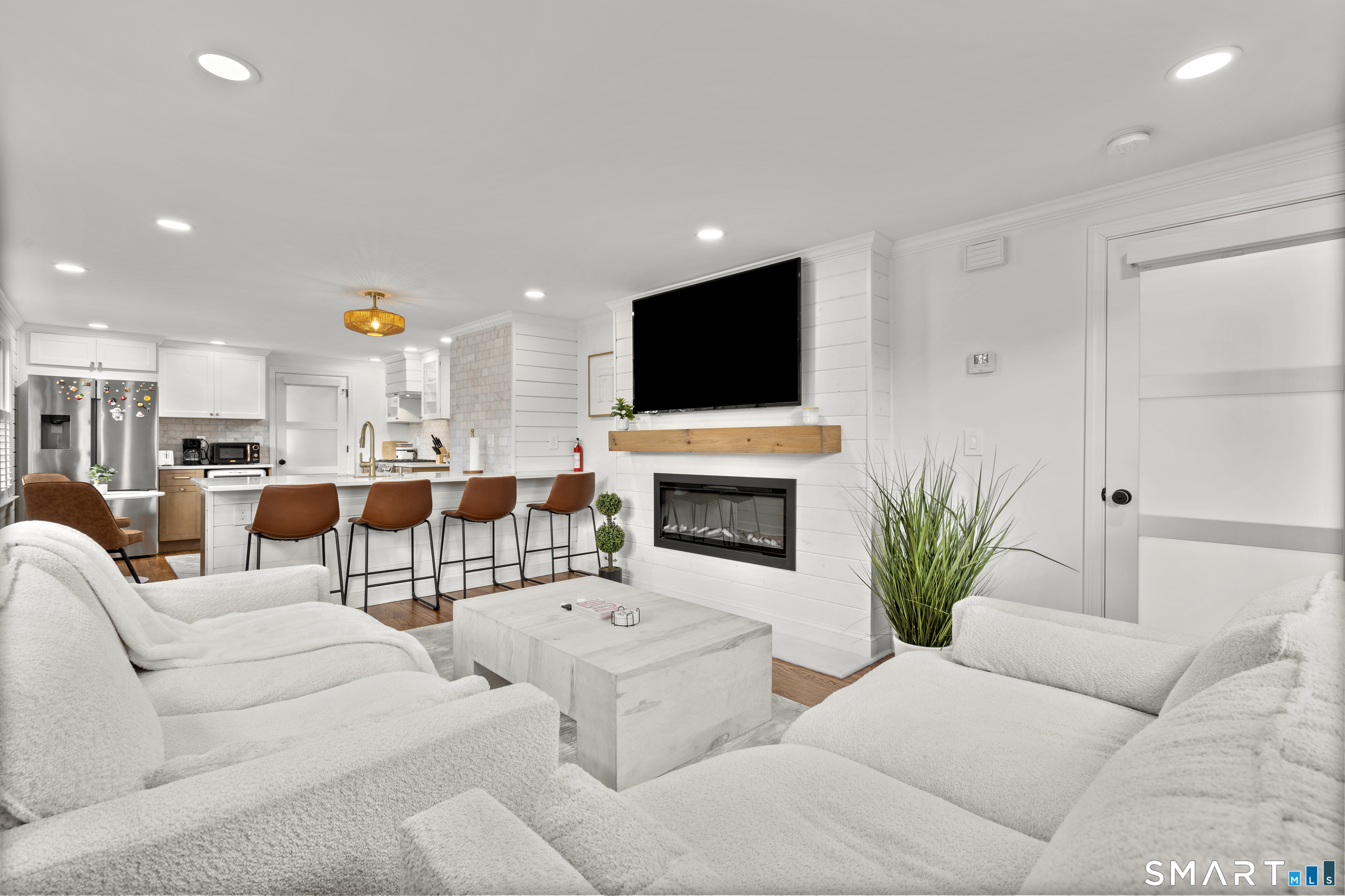 180 Ruane Street, Unit 1 Fairfield, CT 06824 - Photo 5 of 20 a living room with furniture a fireplace and a flat screen tv