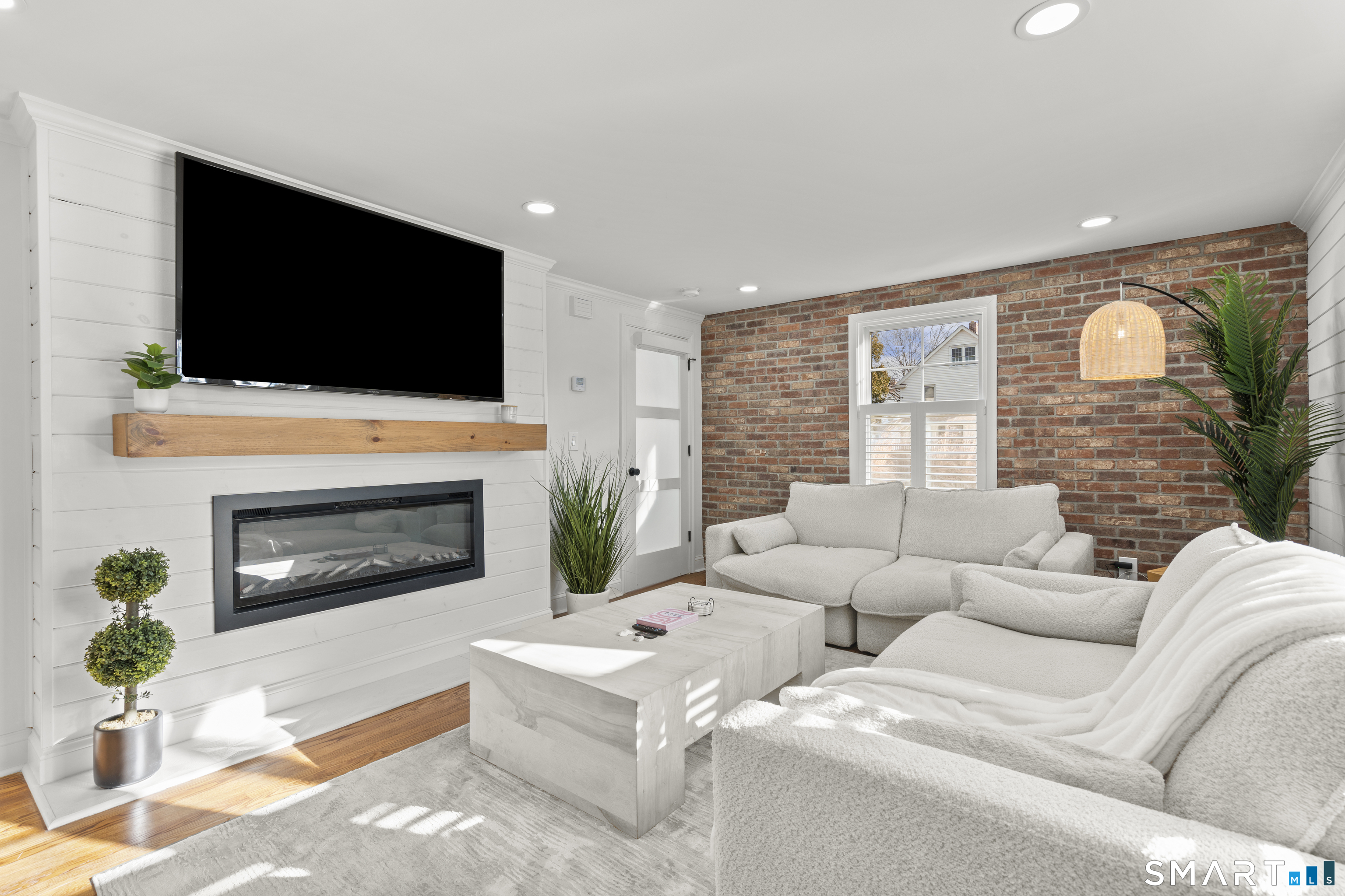 180 Ruane Street, Unit 1 Fairfield, CT 06824 - Photo 6 of 20 a living room with furniture a fireplace and a flat screen tv