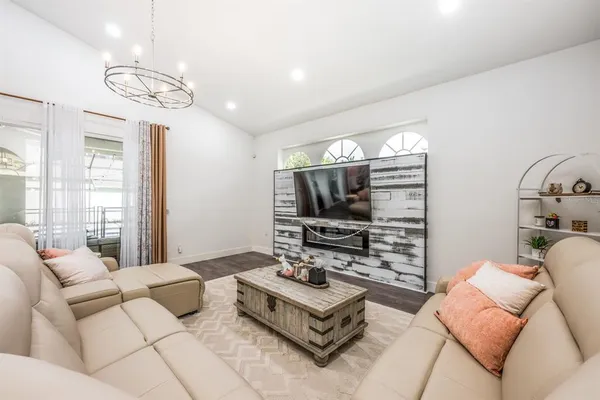 a living room with furniture a flat screen tv and a large window