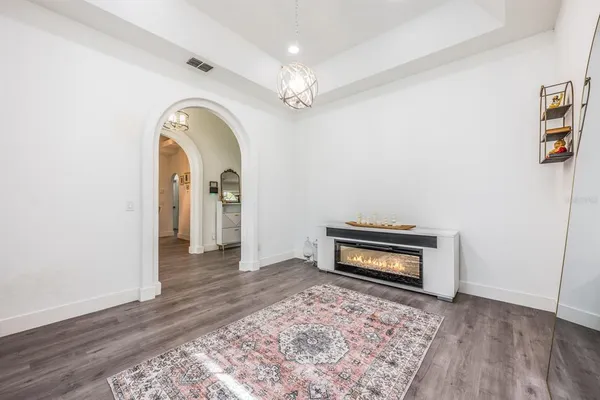 a dining room with furniture a chandelier and wooden floor