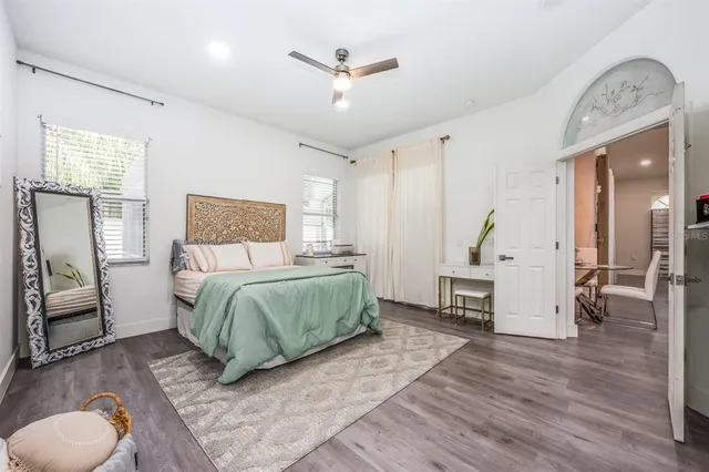 a spacious bedroom with a bed and a flat screen tv