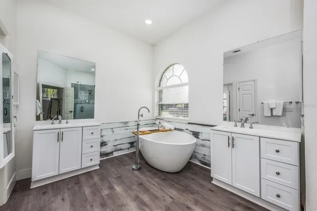 a bathroom with a double vanity sink mirror and shower