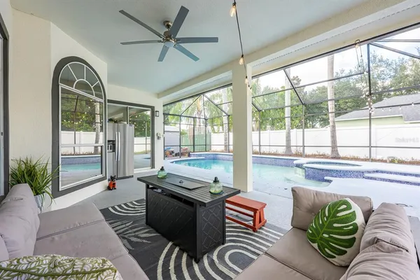 a living room with patio furniture and a chandelier