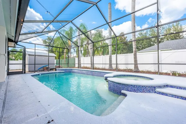a view of a swimming pool with a yard and sitting space