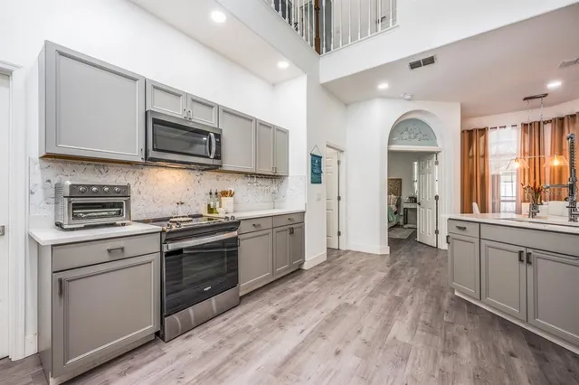a large kitchen with stainless steel appliances granite countertop a stove and a sink