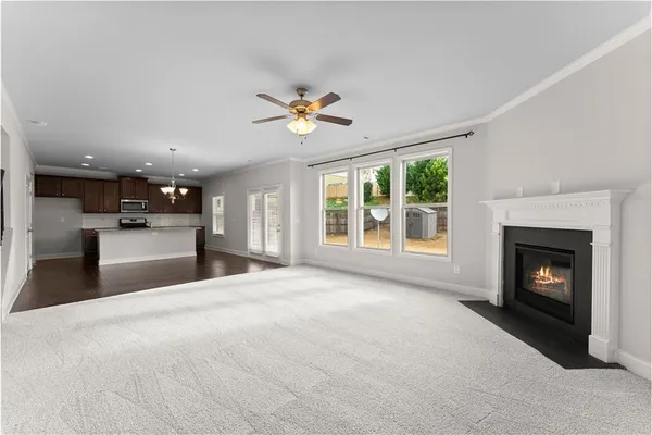 a view of an empty room with a fireplace and a window
