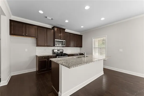 a kitchen with stainless steel appliances granite countertop a stove a sink and a refrigerator