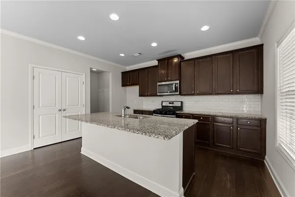a kitchen with a sink stove top oven and refrigerator