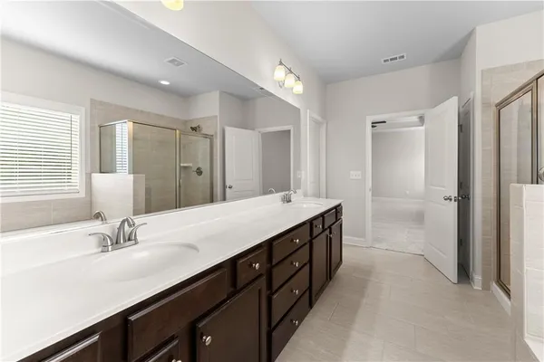 a bathroom with a double vanity sink a mirror and a shower