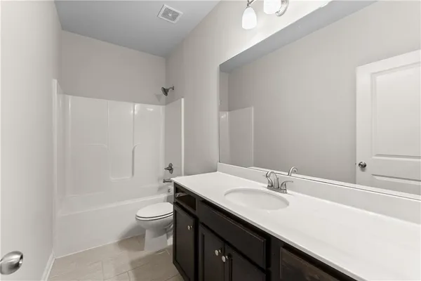 a bathroom with a granite countertop sink toilet a large mirror and shower