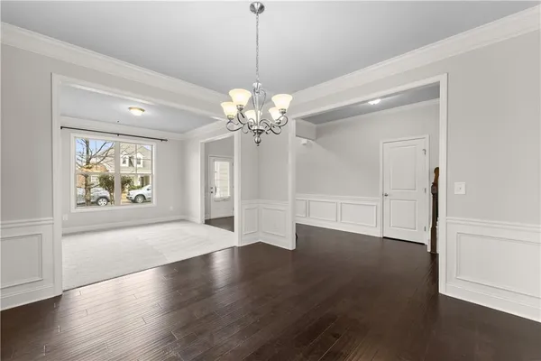 a view of an empty room with wooden floor and window