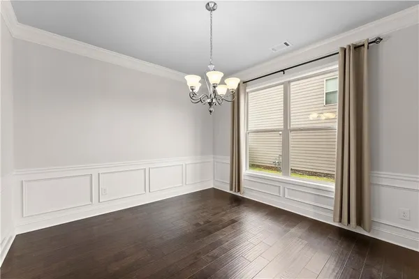 a view of a room with wooden floor and chandelier