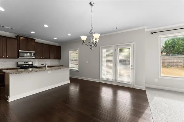 a view of a kitchen with stove and wooden floor