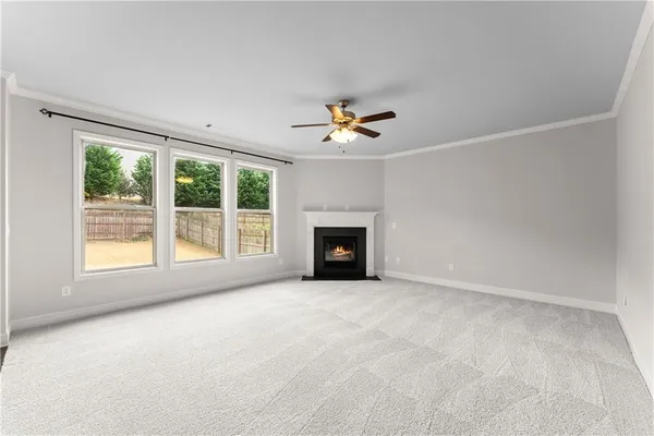 an empty room with ceiling fan and window