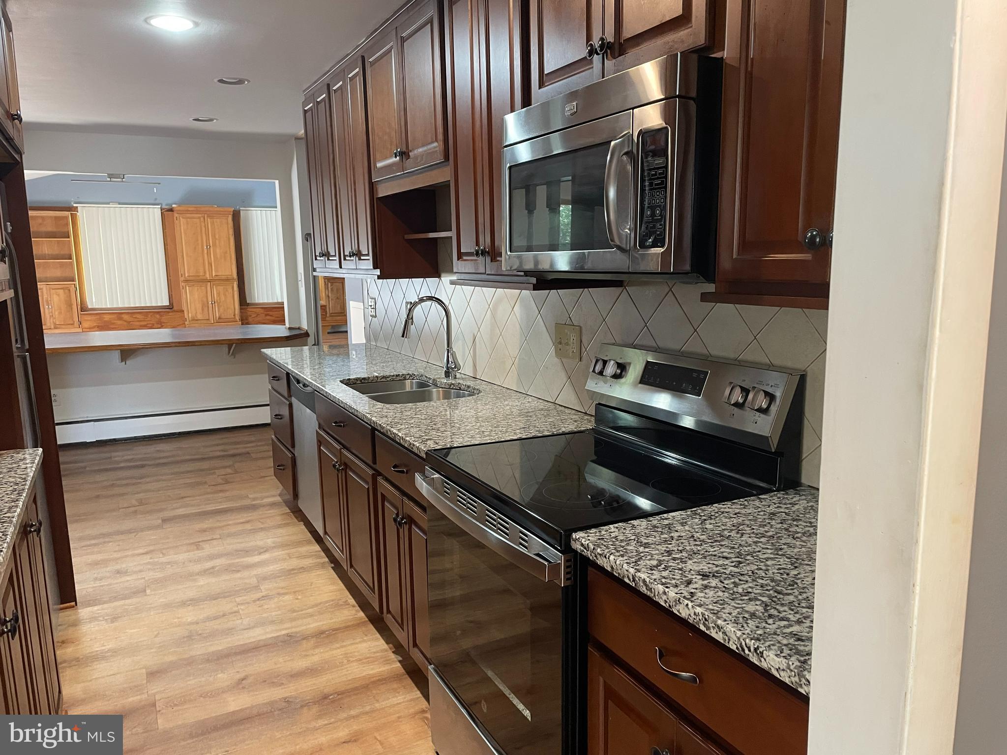 511 Heather Road Exton, PA 19341 - Photo 2 of 9 a kitchen with stainless steel appliances granite countertop a sink stove and microwave