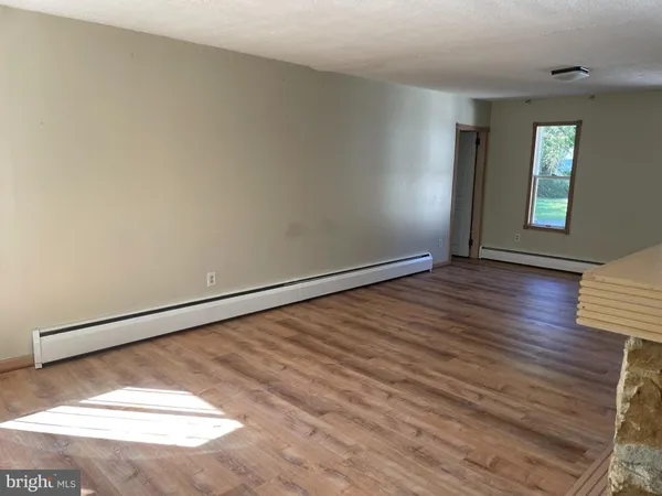 a view of a room with wooden floor and window