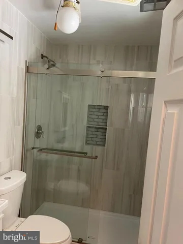 a bathroom with a toilet and a shower