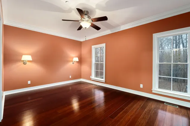a view of room with wooden floor and ceiling fan