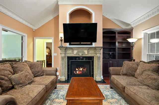 a living room with furniture a flat screen tv and a fireplace